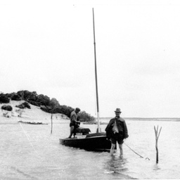 Two men with small boat at its anchorage at Nine Mile Point