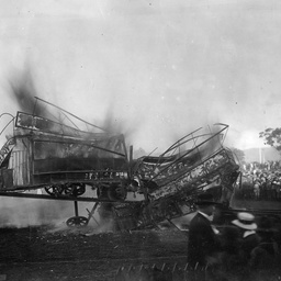 Large crowds watching an old horse tram being destroyed by fire