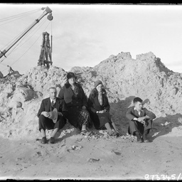 Group sitting on rubble.