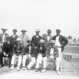 Group of young men posing beside an oval