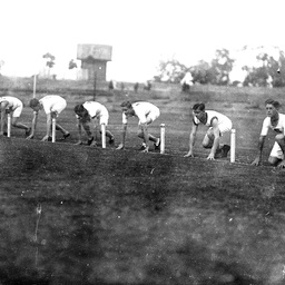 Six male athletes at the start of a race