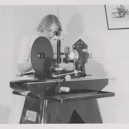 Woman working at an optical projector.