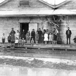Echuca during a flood with a group including children on a verandah