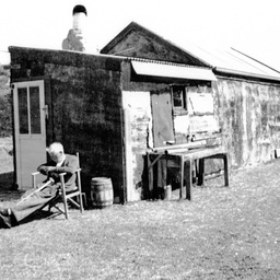 George Ross relaxing in a chair outside a shack at The Coorong