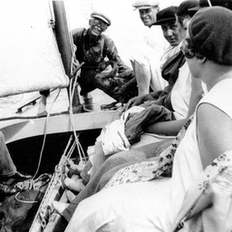 George Ross holding a black swan on board a small yacht on the Lakes