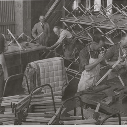 Assembling camp bedsteads for the RAAF.