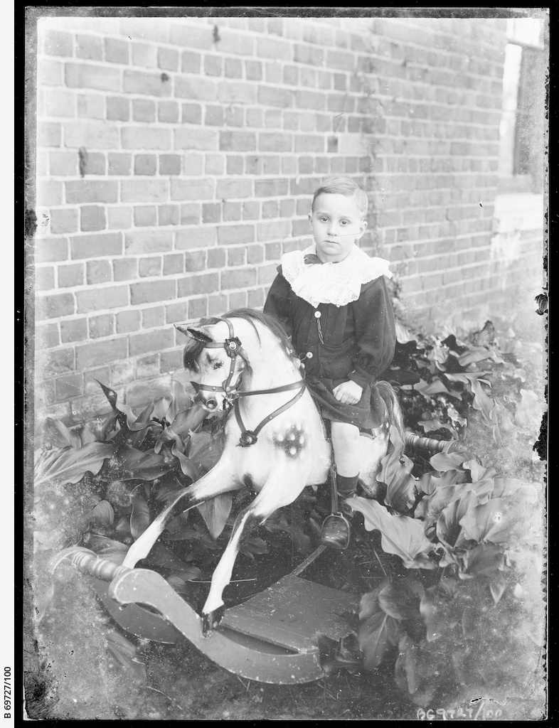 Young boy on a rocking horse • Photograph • State Library of South