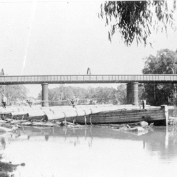 Outrigger barge loaded across with huge logs at Echuca