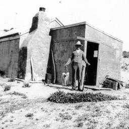 A man with a rifle outide a shack at Nine Mile Point