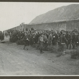 Townspeople gathered by a wall.