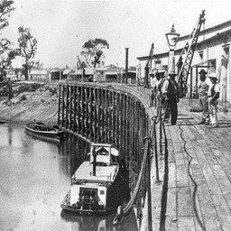 Echuca Wharf with several men standing near a loading crane