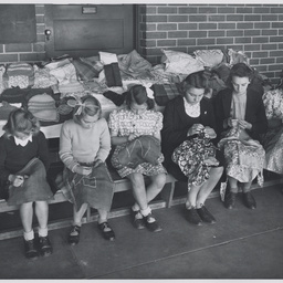 Six girls demonstrating sewing